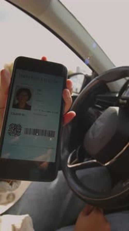 Hand of Anonymous Lady Displaying Digital Drivers License on Smartphone