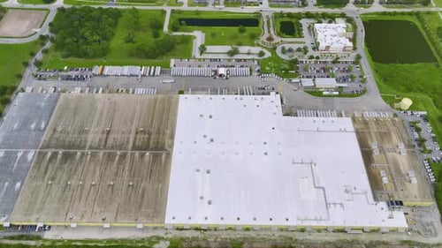 Aerial View of Large Commercial Loading Bay with Many Delivery Trucks Unloading and Uploading Retail