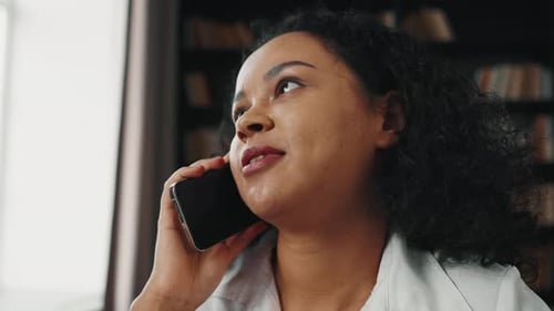 Young Woman Talking on Mobile Phone Indoors