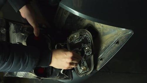 Réparation des feux arrière de voiture, remplacement de l'ampoule par un mécanicien