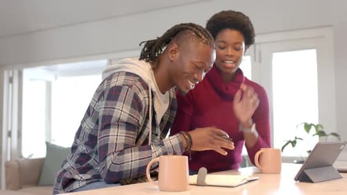 Smiling Couple Using Tablet in Home Kitchen