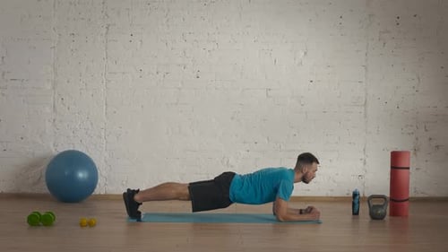 Man Fitness Coach in Sportswear Doing Static Plank Exercise for Online Class at the Home Studio