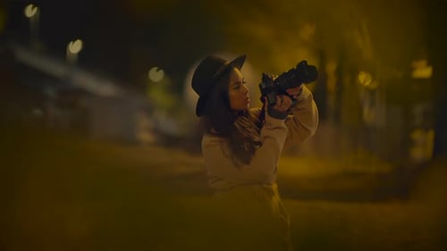 Woman Photographer Takes Pictures at Night in City