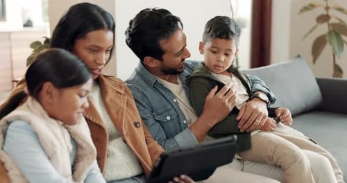 Family Relaxing on Sofa with Tablet