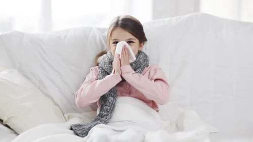 Sick Child Lying on Couch Blowing Nose Coughing