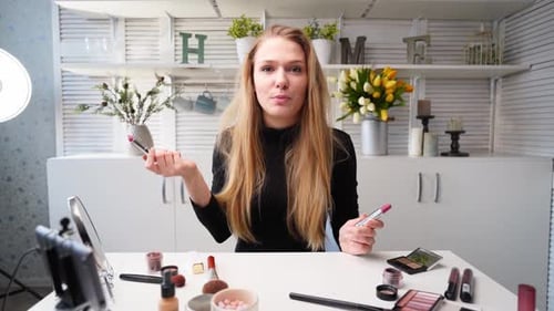 Mujer vloguera aplica lápiz labial en los labios, bloguera de belleza, mujer filmando una rutina diaria de maquillaje, tutorial