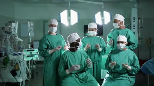 Portrait of diverse surgeons wearing surgical gowns in operating theatre, slow motion