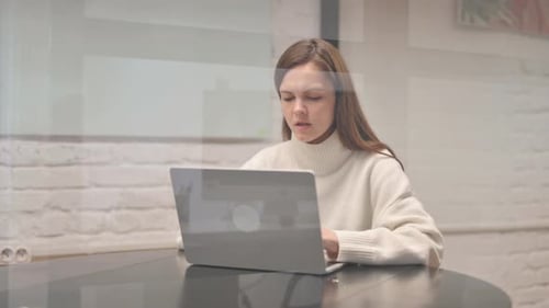 Woman Working on Laptop While Coughing