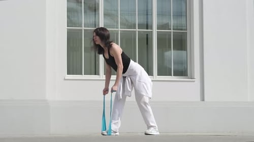 Woman Exercising With Resistance Band in Urban Setting