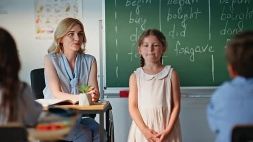 Girl Presents in Classroom with Teacher Listening