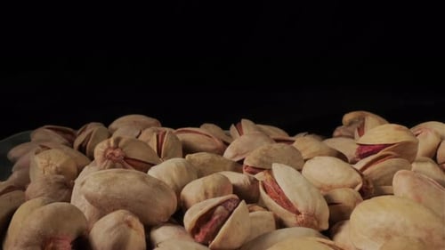 Pile of Shelled Pistachios Against Black Background