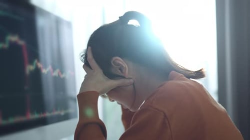 Worried Woman Watching Graph on Computer Monitor
