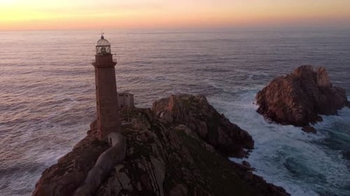 Luftaufnahme eines Leuchtturms bei Sonnenuntergang, Spitze einer Felsformation, Ozeanklippe, natürliche Meereslandschaft in Spanien, Gali