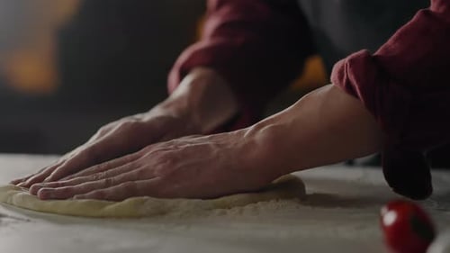 Kochen, Chefkoch in Aktion Beim professionellen Zubereiten von Pizza aus Teigformen entsteht eine runde Pizza