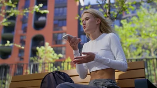 Young Woman Using Voice Command on Phone Outdoors