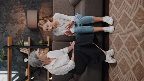 Young Woman and Senior Woman Conversing on Couch