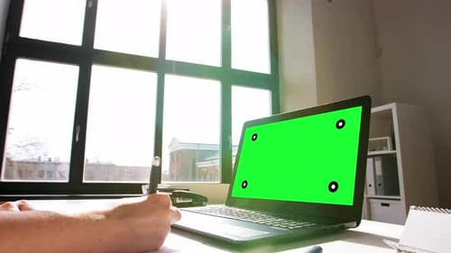Laptop with Green Screen in Bright Office Setting