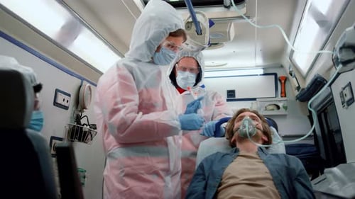 Medical personnel tending to patient inside ambulance