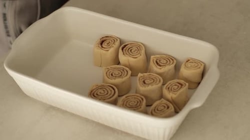Arranging Cinnamon Rolls into Baking Dish for Cooking