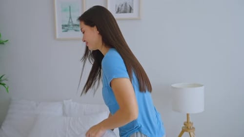 Woman Gets Into Bed with White Bedding