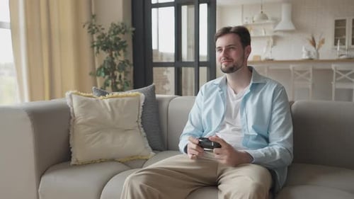 Man Playing Video Game on Couch at Home