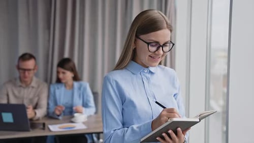 Businesswoman Taking Notes in Bright Urban Office
