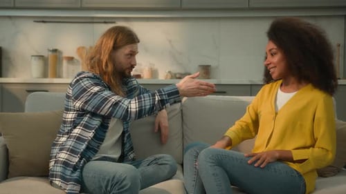 Man and Woman Chatting on Sofa Indoors