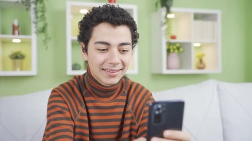 Young Adult Using Phone and Smiling on Couch