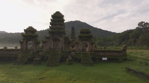 Aerial view of misty temple surrounded by forest and lake, Bali.