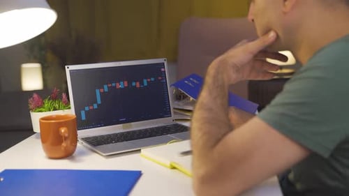 Homem examinando e pensando no gráfico financeiro.