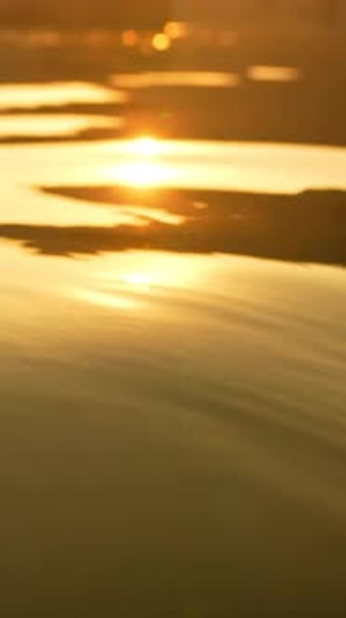 Abstrakter Meeres-Sommer-Sonnenuntergang Natur-Hintergrund Kleine Wellen auf goldener Wasseroberfläche in Bewegung