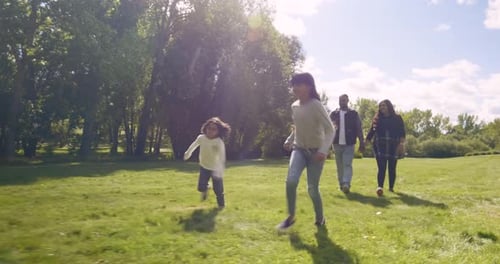 Happy Family Walking and Running in Sunny Autumn Park Affectionate