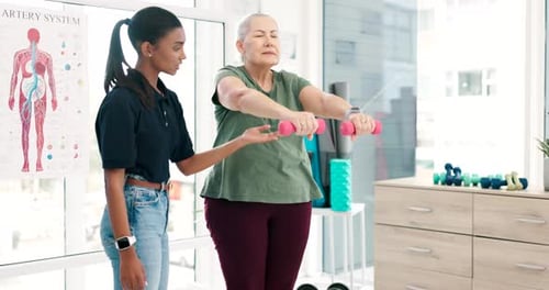 Physical Therapist Helps Senior with Dumbbell Exercises