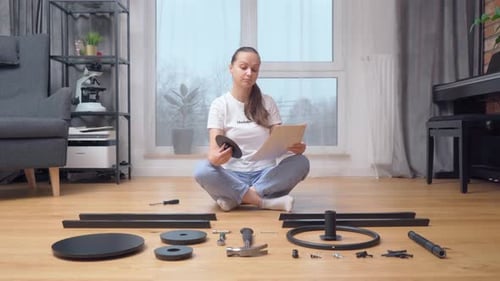 Woman Assembling Furniture at Home Following Instructions