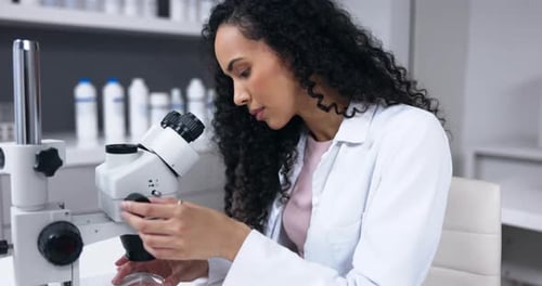 Woman Scientist Looking Through Microscope in Laboratory Setting