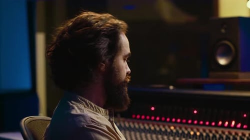Man Working on Sound Mixing Board in Studio