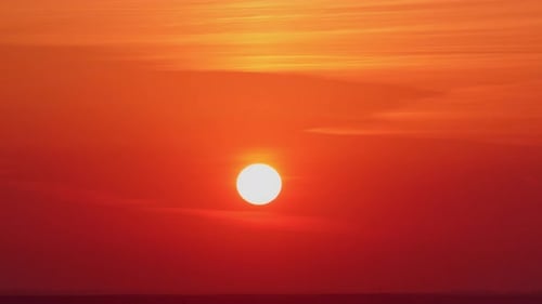 Beautiful red sunset over the horizon with clouds in the sky, timelapse.