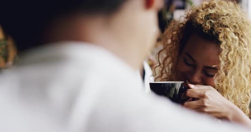 4k video footage of an attractive young woman sitting and enjoying a coffee during a date in a cafe