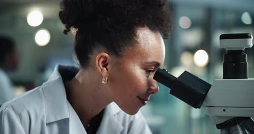 Woman Scientist Uses Microscope in Modern Laboratory