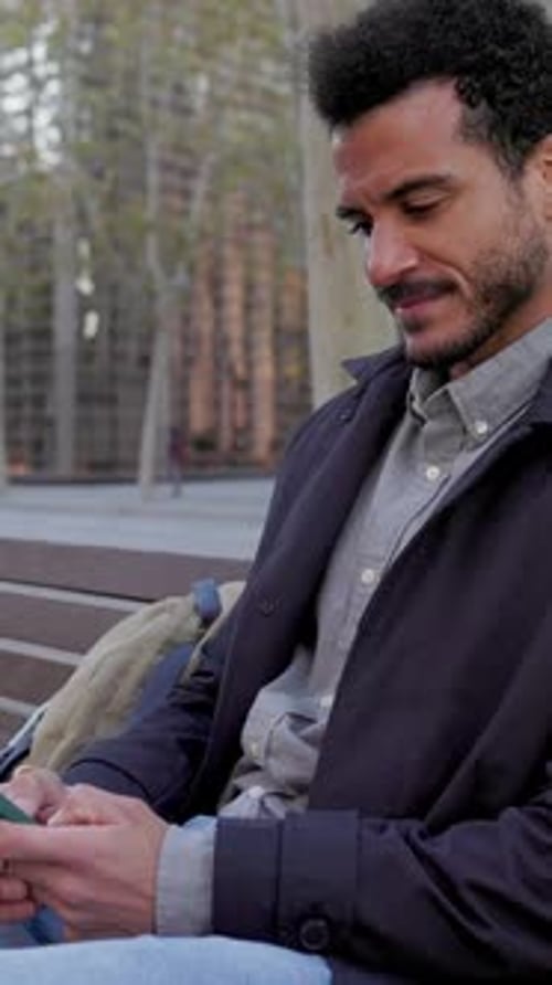Young Businessman Using a Smartphone on a Bench in the City