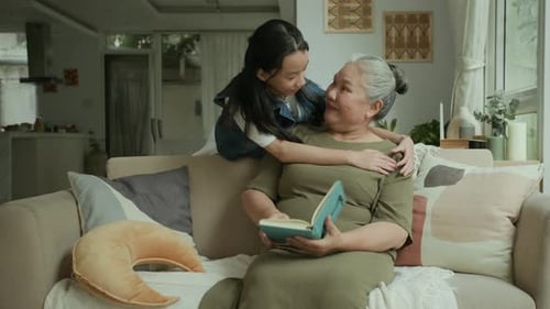 Grandmother and Granddaughter Embracing on the Couch