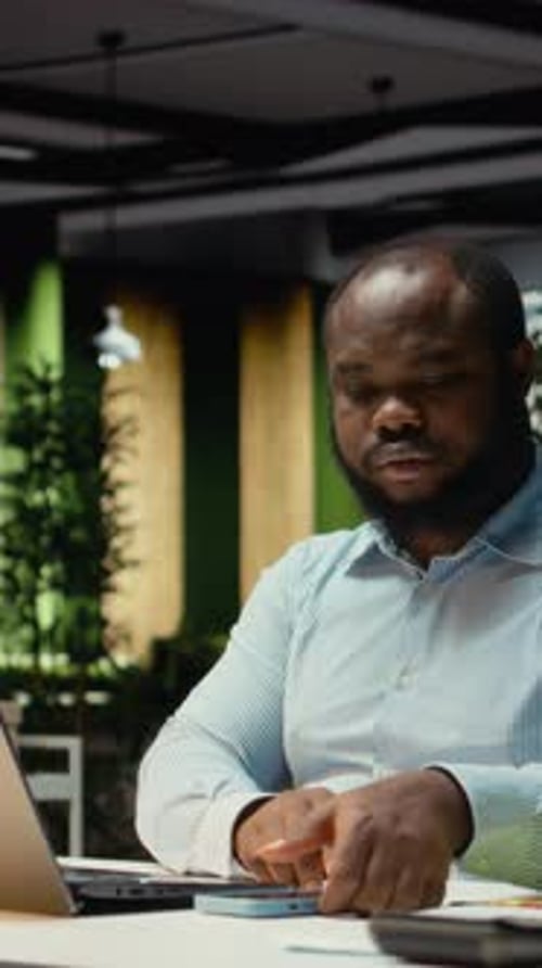 Vertical Video Black Businessman Checking the Time and Closing His Desk Lamp at the Office