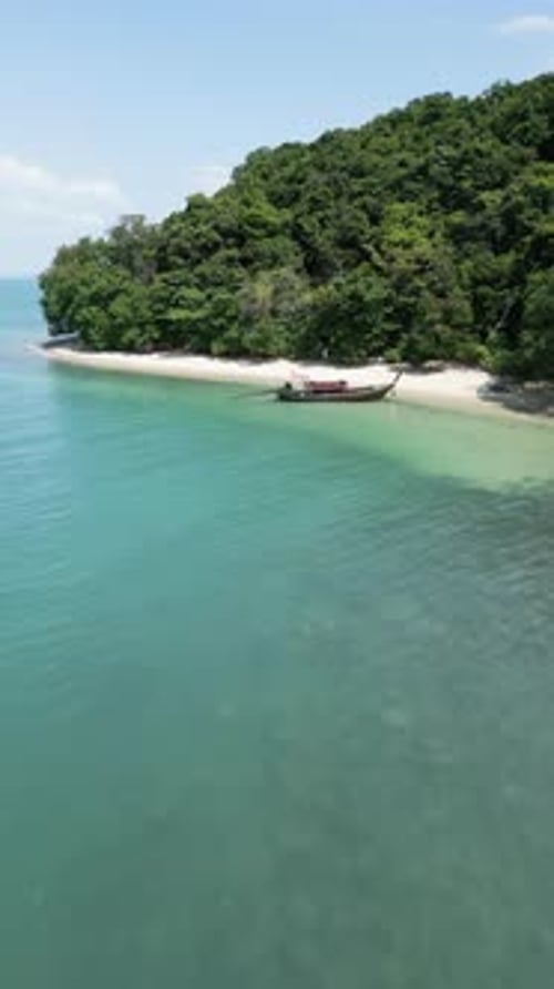Vertical Video Aerial View of a Sailboat Near a Tropical Island Shore with Coastal Cliffs