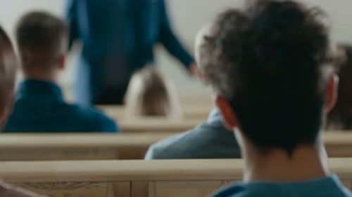 Vista posterior de los estudiantes en la sala de conferencias escuchando a un profesor prominente dando una conferencia. Br