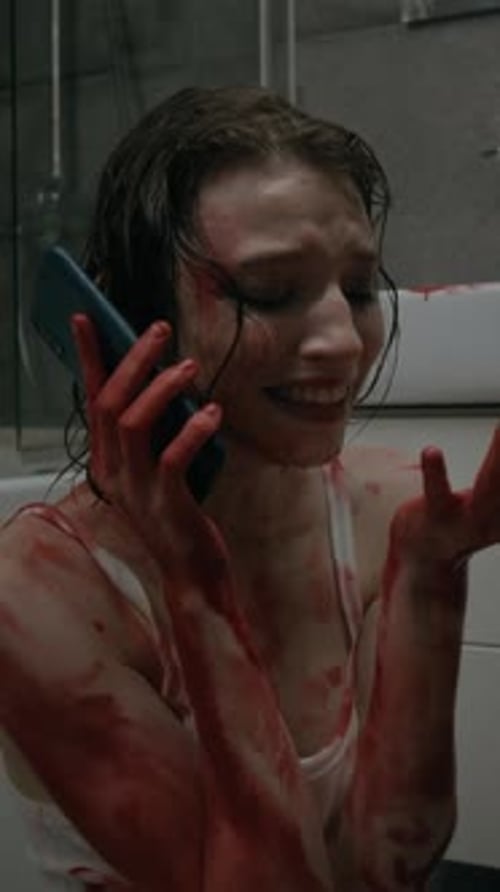 Distressed Woman Covered in Blood on the Phone