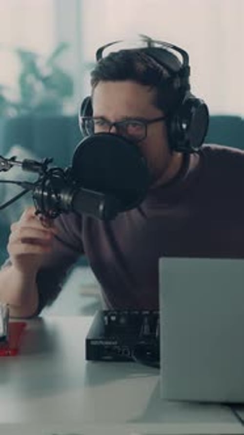 Young Adult Male Recording Podcast with Audio Mixer