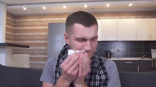 Young Man Suffering from Cold Using Nasal Spray