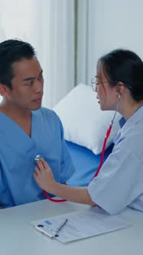 Vertical footage of Doctor examining patient in hospital.