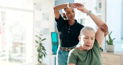 Young Woman Helping Senior with Arm Stretches