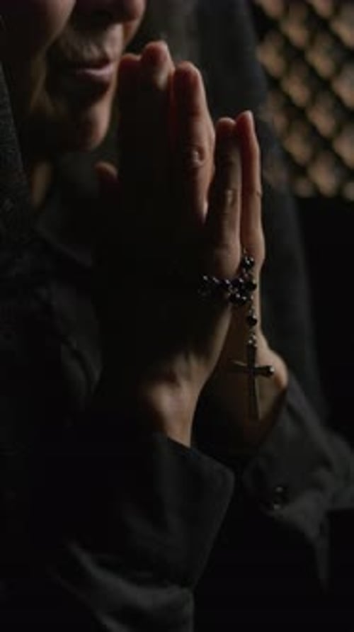 Close-Up of Elderly Woman Holding Rosary and Praying in Confessional Booth